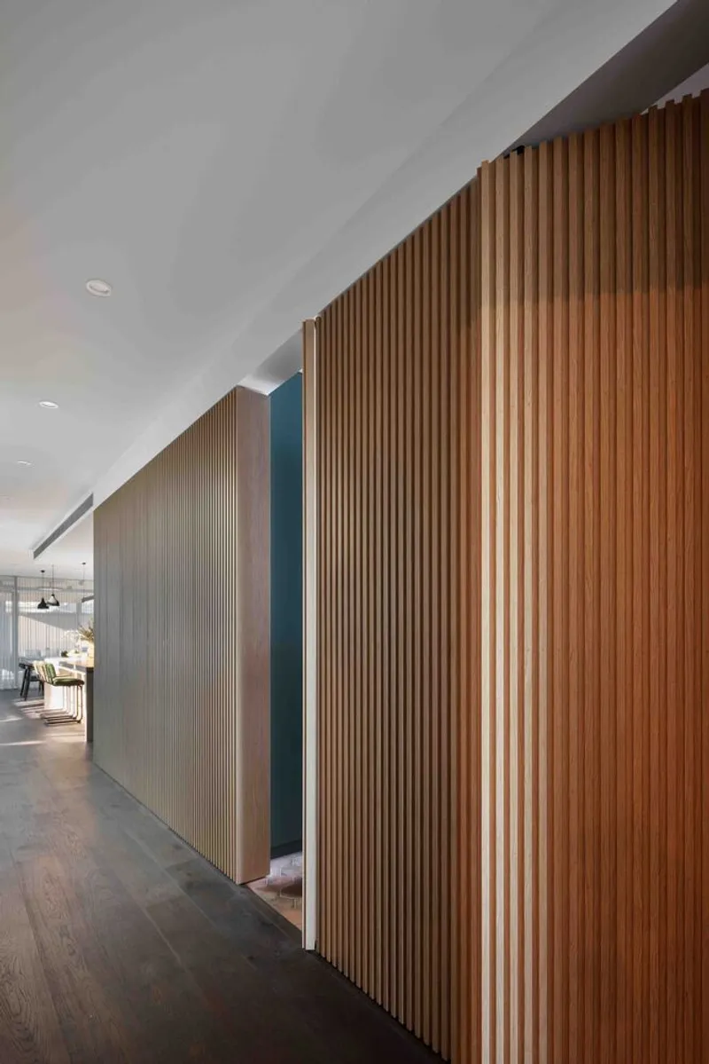 Corridor with vertical timber slat wall featuring a recessed doorway opening in dark blue paint