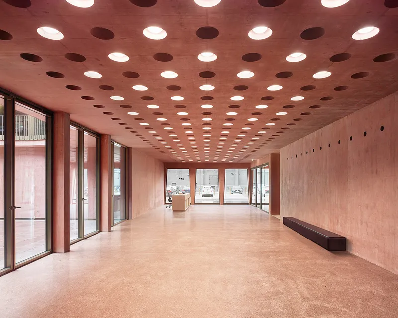 Ground-floor lobby with circular recessed ceiling lights and pink-toned polished flooring