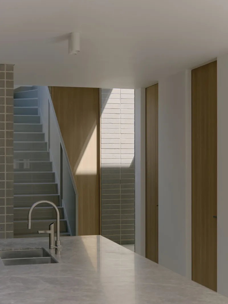 Interior view toward grey tiled wall and timber doors with diagonal shadow from skylight above