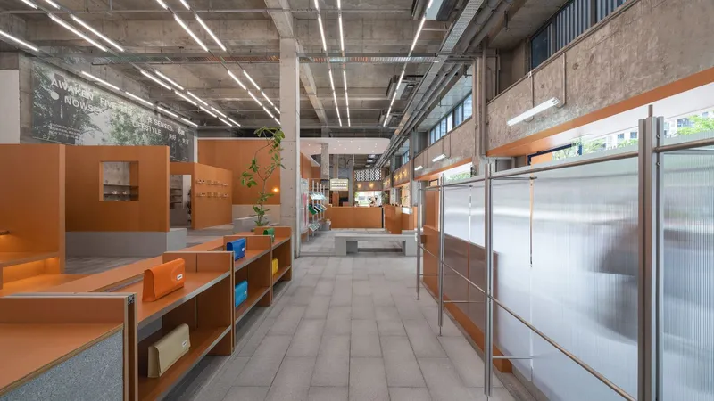 Long view of the interior corridor with orange partition walls and translucent panels beneath exposed concrete ceiling