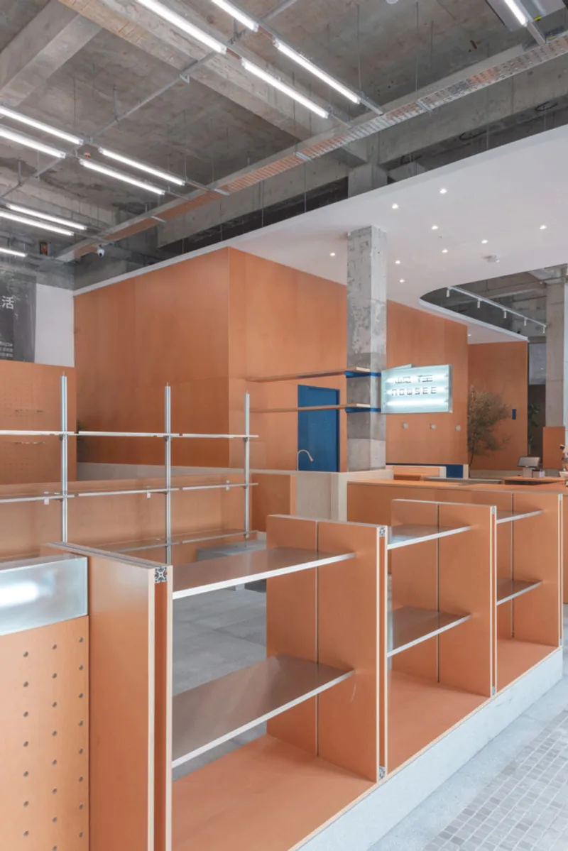 Modular plywood shelving units with white metal rails beneath exposed concrete ceiling and lighting tracks