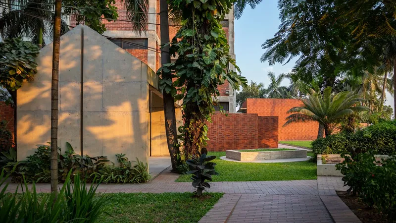 Translucent glass volume beside brick structure in garden setting at dusk with palms and tropical planting