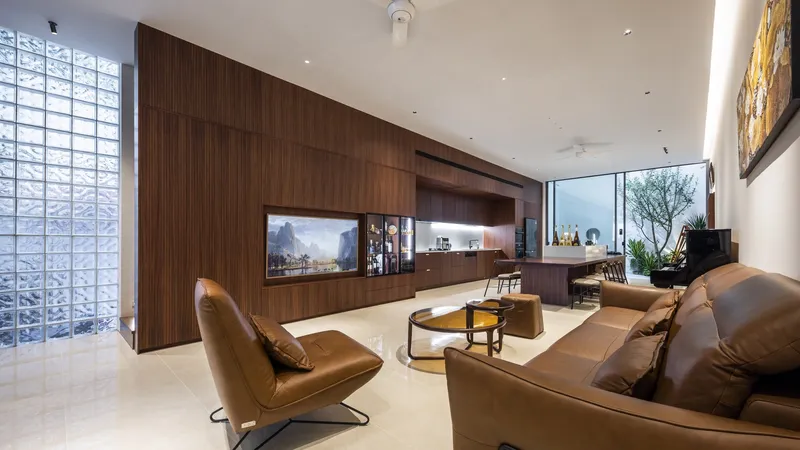 Living room with timber paneled wall and glass block partition filtering daylight
