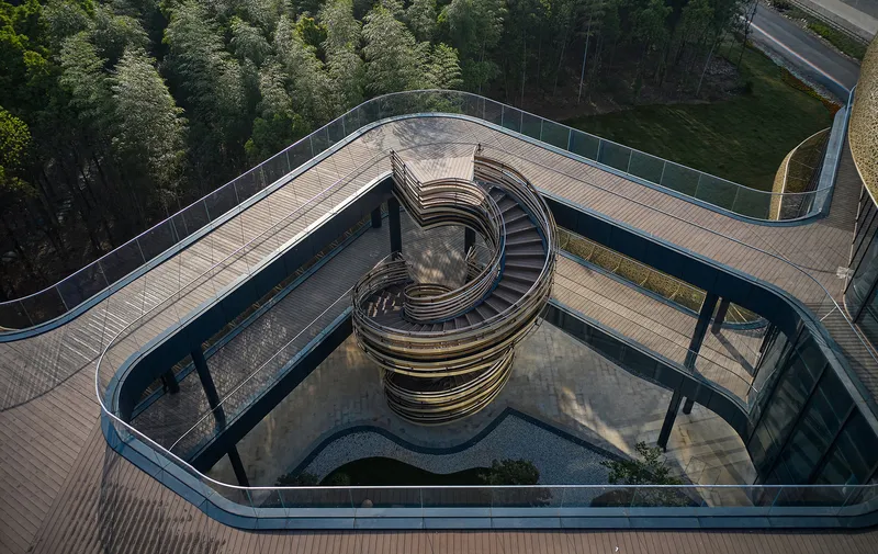 Aerial view of a spiral staircase within a triangular courtyard surrounded by timber decking