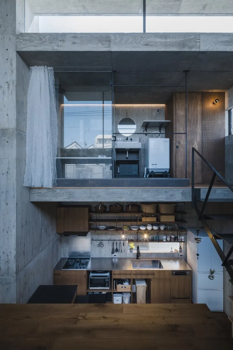 Vertical section through stacked kitchens with concrete platforms, steel railings, and timber cabinetry under pendant lights