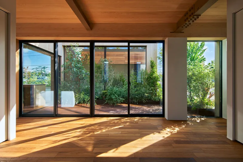 Herringbone timber floor leading to sliding glass doors that open onto a deck with container plantings