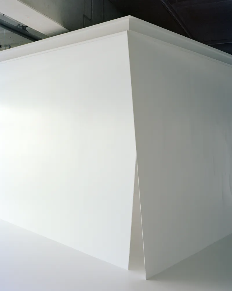 Close-up of the crisp corner joint where two white partition walls meet