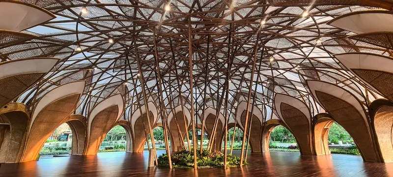Central lattice bamboo structure beneath the dome canopy with arched openings framing the pool beyond