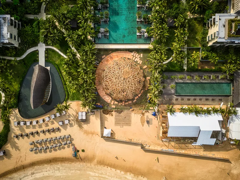 Overhead view of the circular pavilion between the beach and a rectangular swimming pool