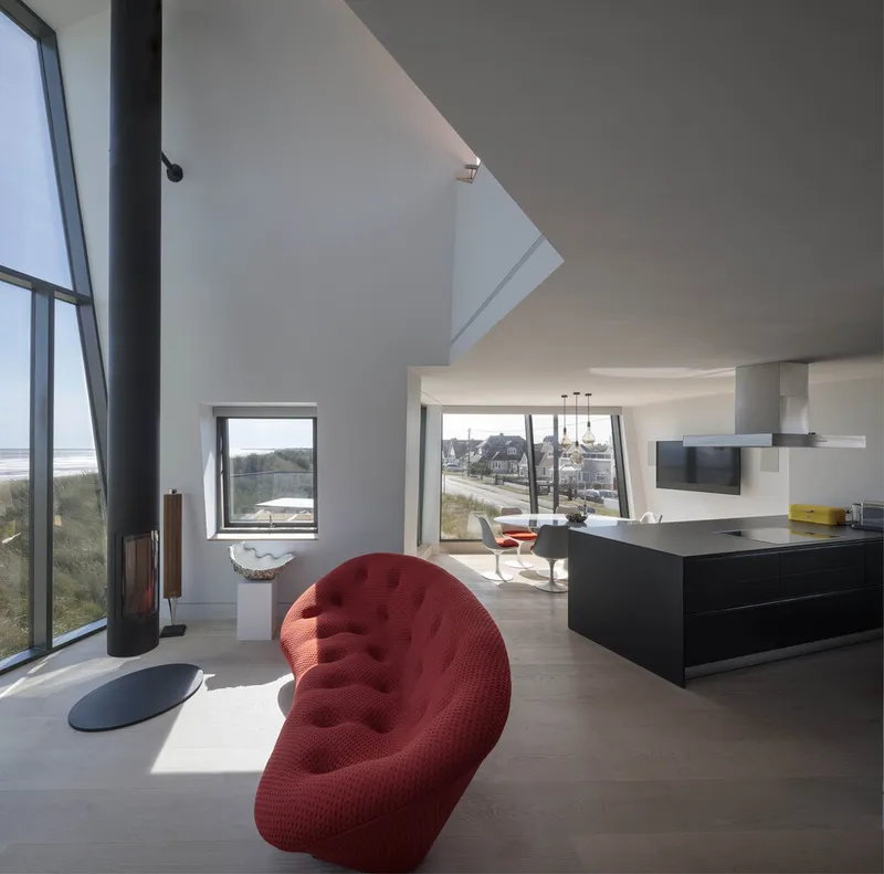 Double-height living space with skylight, wood stove, and view through to the coast