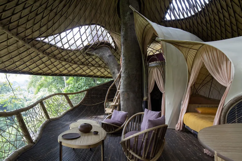 Open terrace with woven bamboo shell roof, canopied sleeping alcove, and seating area overlooking jungle foliage