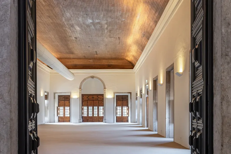 Gallery room with timber slat ceiling and triple arched opening to wooden shuttered windows