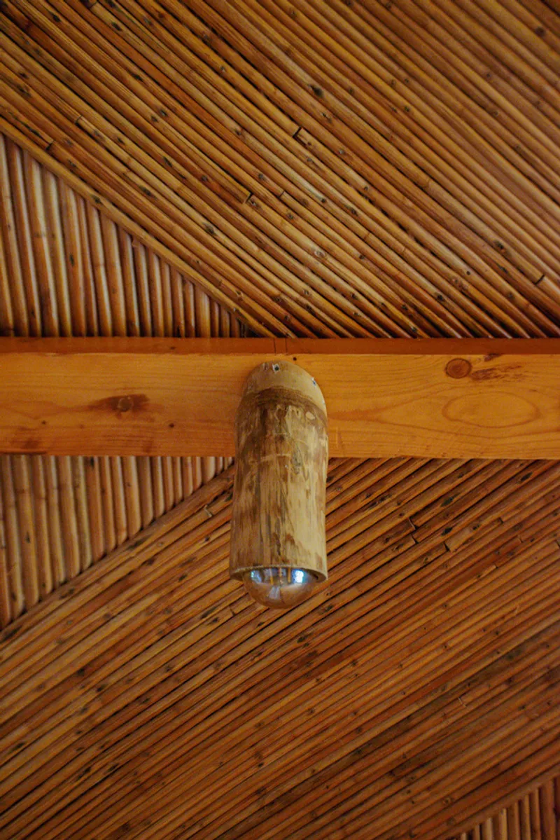 Diagonal timber slat ceiling with exposed beam and cylindrical bamboo pendant light fixture