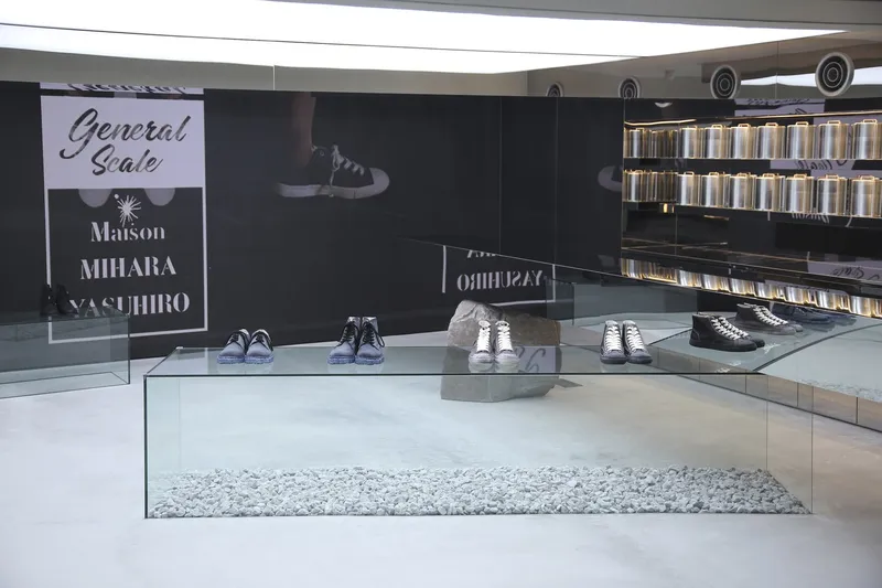 Retail interior with glass display boxes and a black wall featuring signage and product imagery