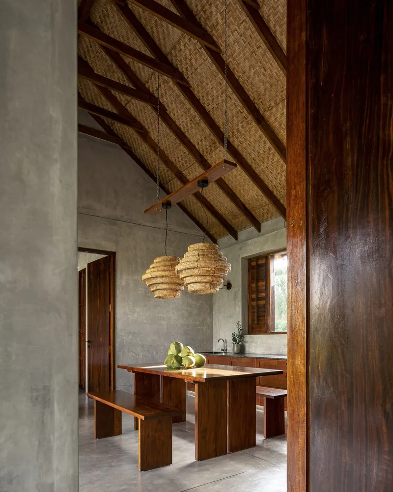 Dining area with woven pendant lights hanging beneath exposed timber rafters and thatched ceiling panels
