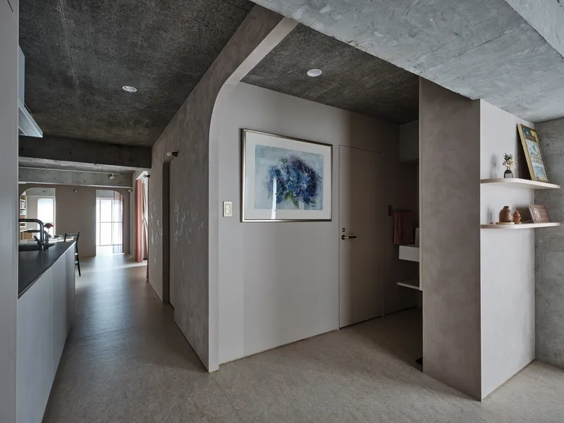 Entry corridor with white niche, painted ceiling vaults and artwork beside a doorway