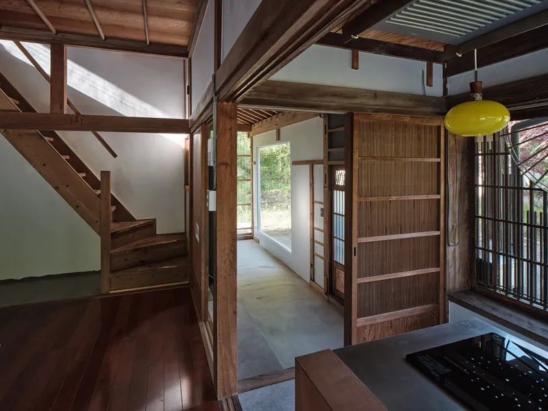 Entry hall with sliding screen panels and timber staircase beneath exposed structural beams
