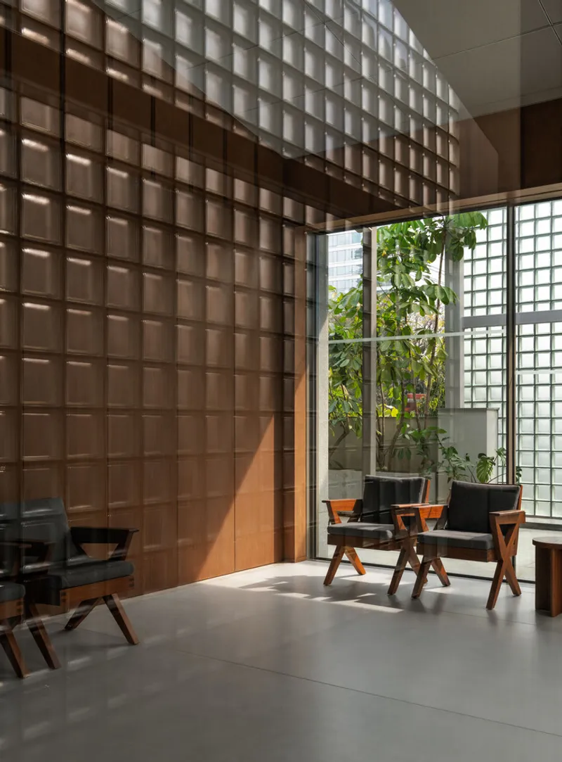 Translucent grid wall beside planted courtyard with glass block screen filtering daylight