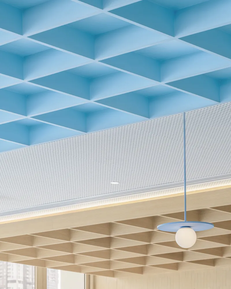 Detail of blue coffered ceiling above timber waffle grid with pendant globe light and perforated panels