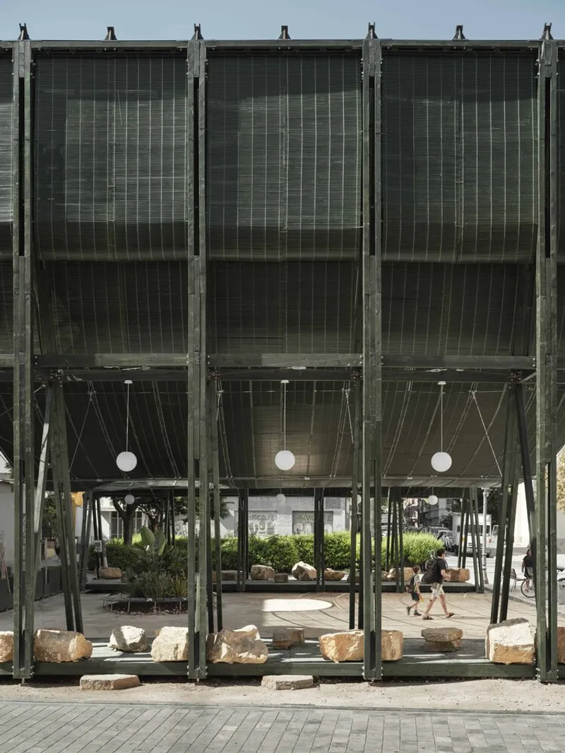 Frontal elevation showing repeating steel bays with mesh screens and suspended globe lights between columns
