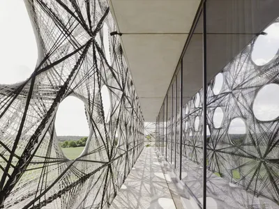 allmannwappner and Menges Scheffler Wrap a University Building in Robotically Woven Fiber Tiles