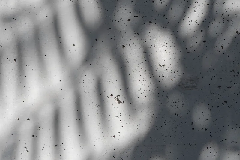 Aerial view of a person walking across a white concrete surface with shadows