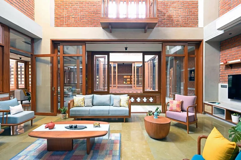 Living area opening onto central courtyard through timber-framed folding glass doors and clerestory windows