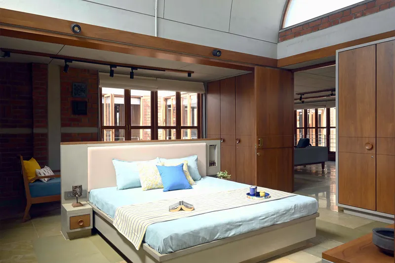 Bedroom with timber wardrobes and clerestory windows overlooking the interior courtyard beyond