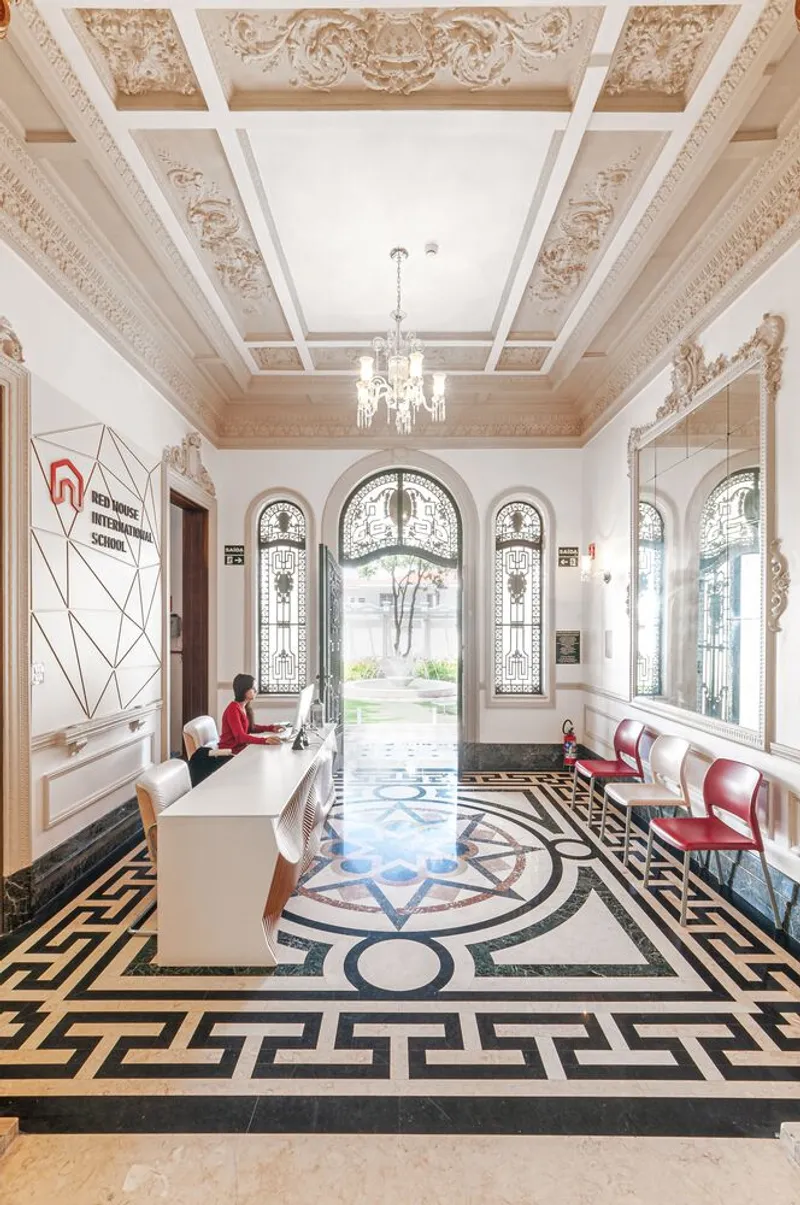 Entrance hall with ornamental plaster ceiling, geometric floor tile pattern and arched glazed doors framing a courtyard beyond