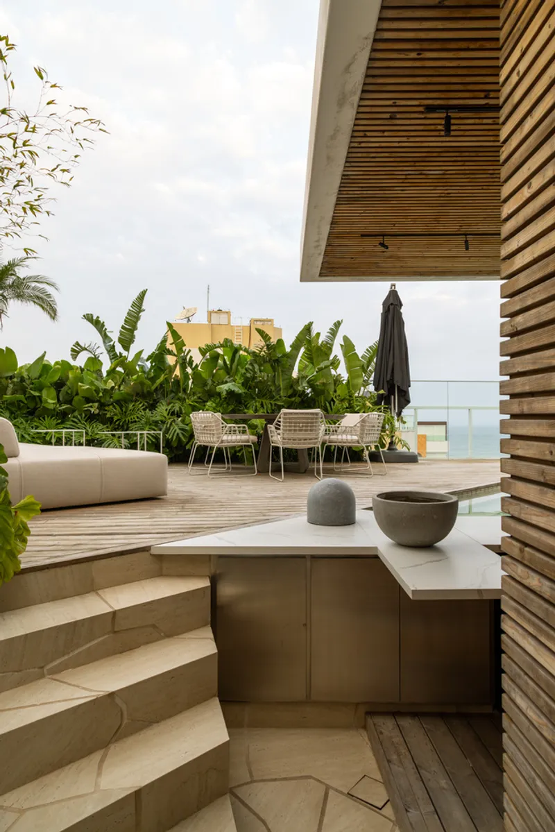 Rooftop terrace with slatted timber canopy, curved stone steps and tropical plantings