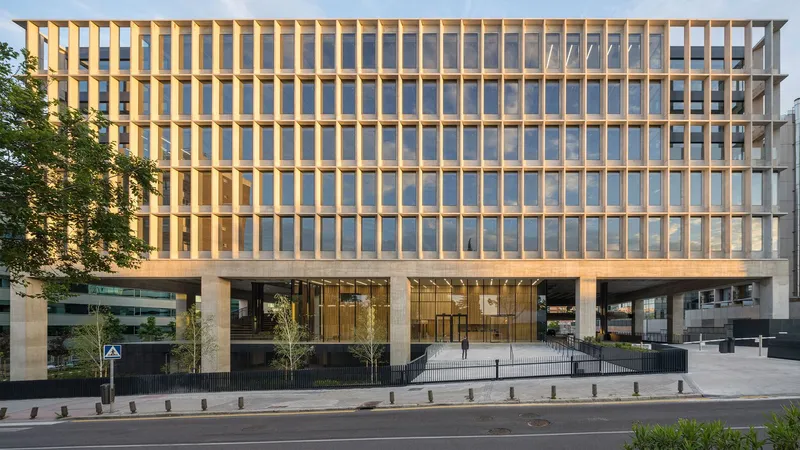 Street view of the timber-louvred facade elevated on concrete columns with glass entry lobby below