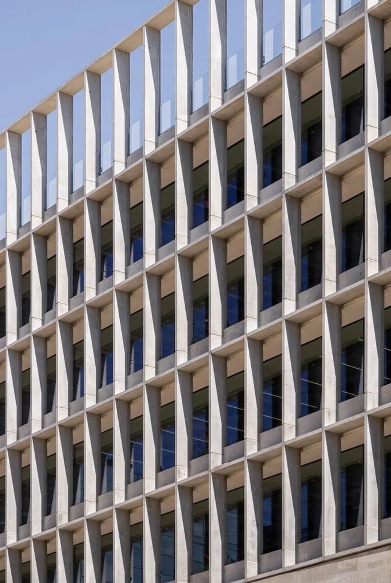Close-up of the vertical sunshading fins in concrete with glazed openings between each bay