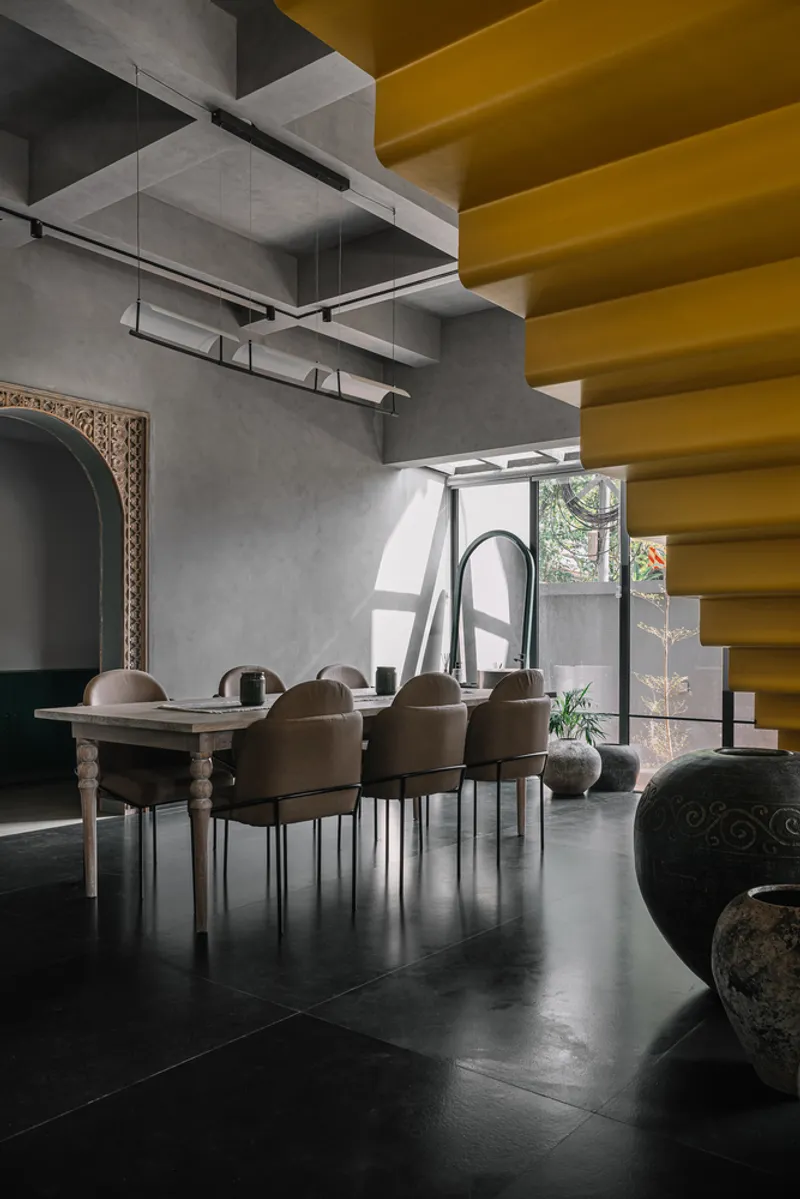 Dining area with yellow ceiling beams and daylight streaming through the glazed doorway