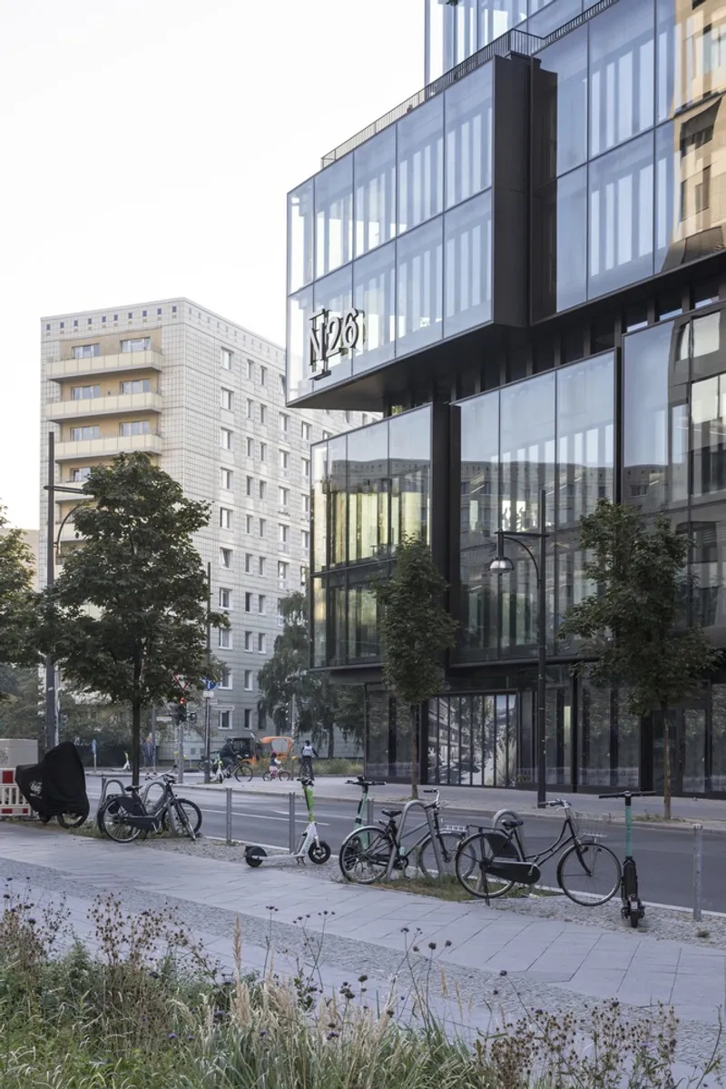 Street-level view of the glass facade and cantilevered upper floors with bicycles parked in foreground