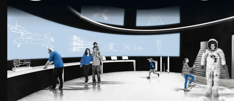 Exhibition hall with curved projection screens displaying technical diagrams and a spacesuit figure among visitors