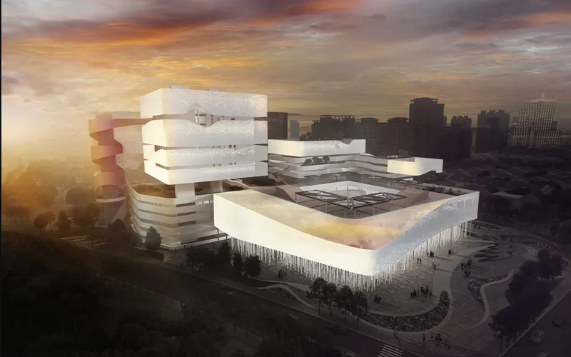 Aerial view of the layered white volumes and rooftop terrace at golden hour with cityscape beyond