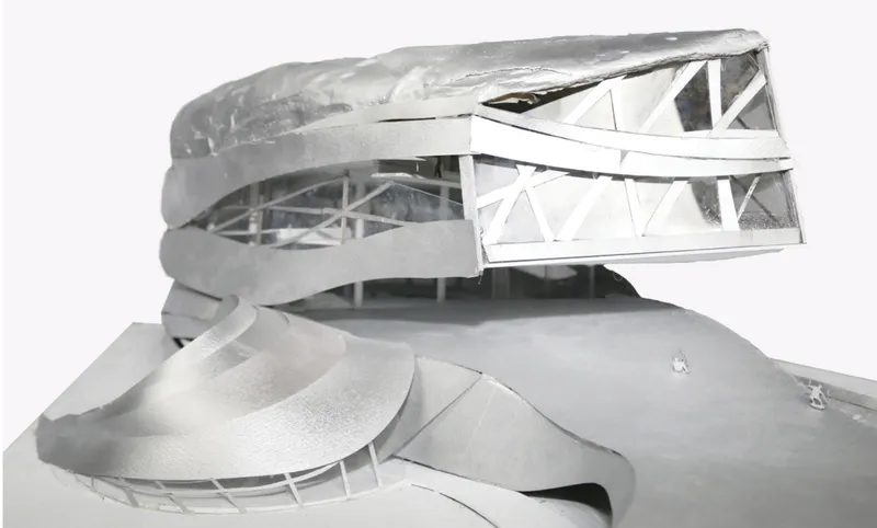 Physical model showing spiraling levels with exposed white structural framework and translucent roof shell