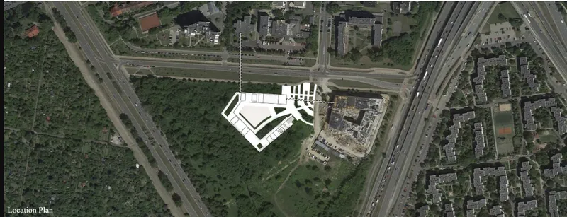 Aerial site plan showing angular white building footprint adjacent to highways and residential neighborhoods