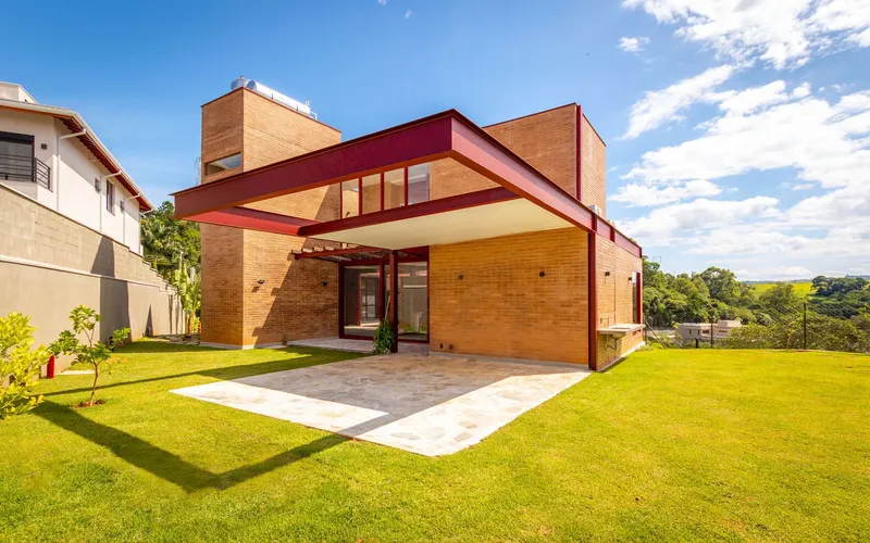 Entry facade with red canopy sheltering the patio under a partly cloudy sky