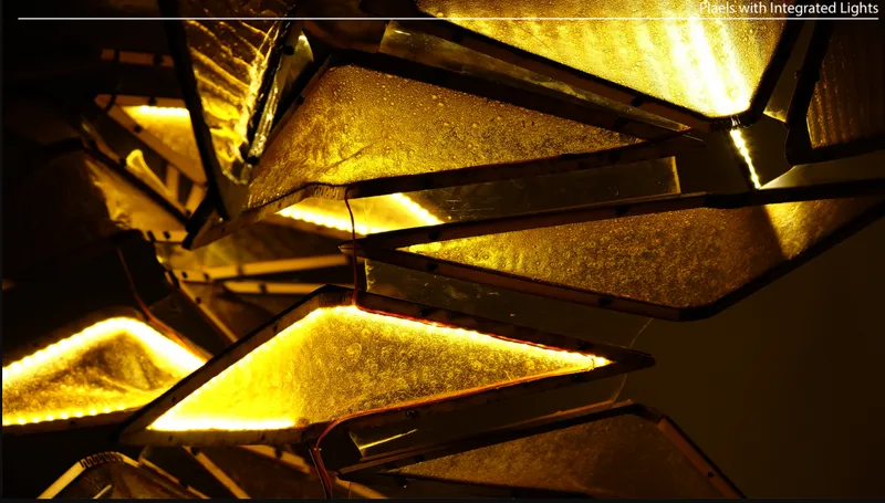 Close-up of triangular glass panels with integrated edge lighting casting warm yellow glow on textured surfaces