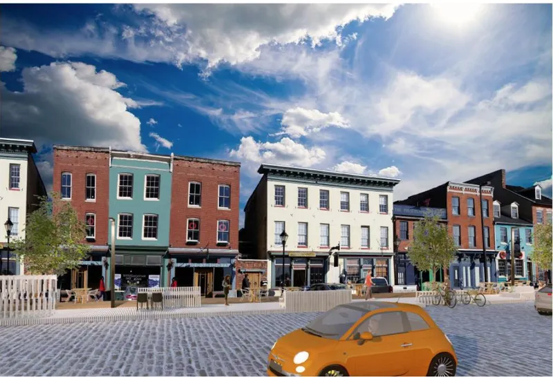 Street view of historic brick storefronts with a paved plaza and orange compact car under dramatic clouds