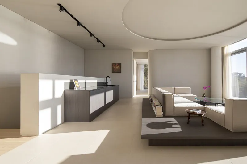 Living room with curved ceiling soffit and kitchen peninsula in soft afternoon light