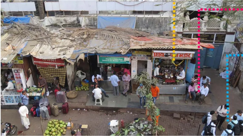 Overhead view of makeshift market stalls with corrugated roofs and vendors selling produce in an open courtyard