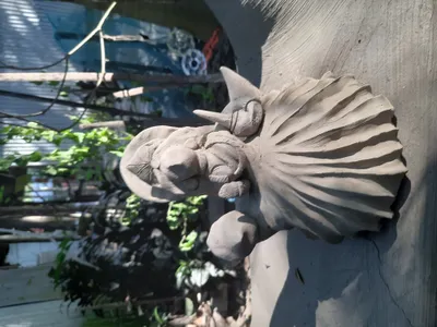 This image showcases a unique clay sculpture, possibly handmade, with intricate details and an organ