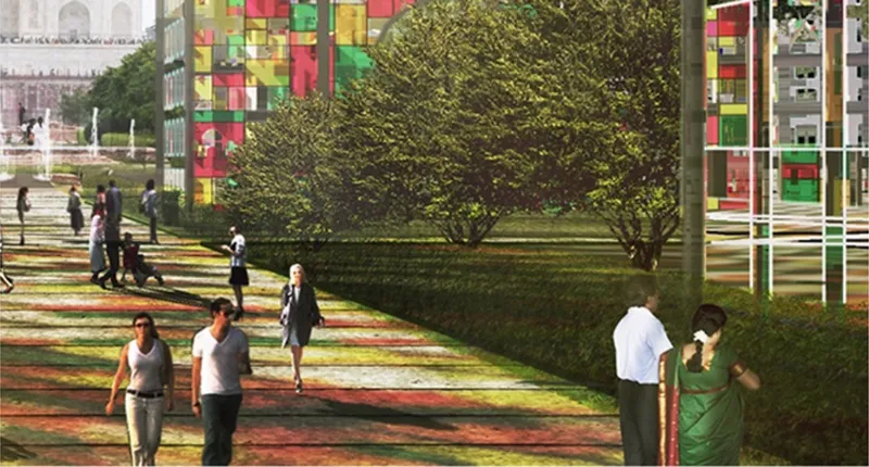 Ground-level view of colored glass columns casting patterned shadows across lawn with visitors and trees