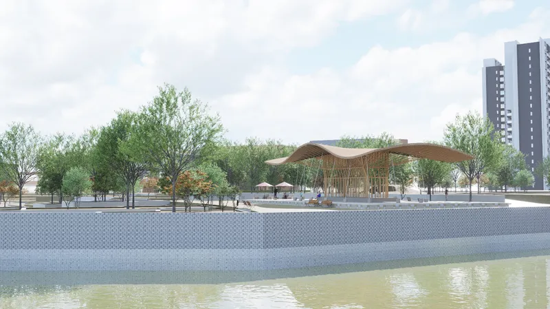 View of pavilion along waterfront with paved platform trees and residential towers in background