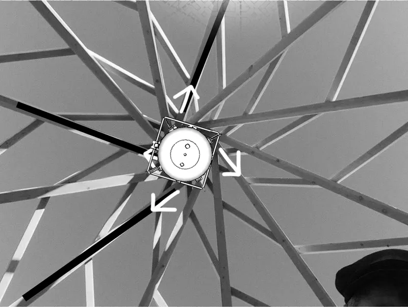 Underside view of radial structural beams converging at central hub with arrows indicating directional flow
