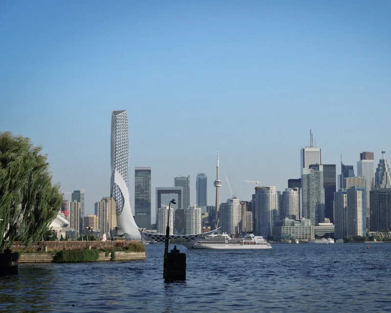 View of the twisted perforated tower rising above the harbor waterfront under clear afternoon light