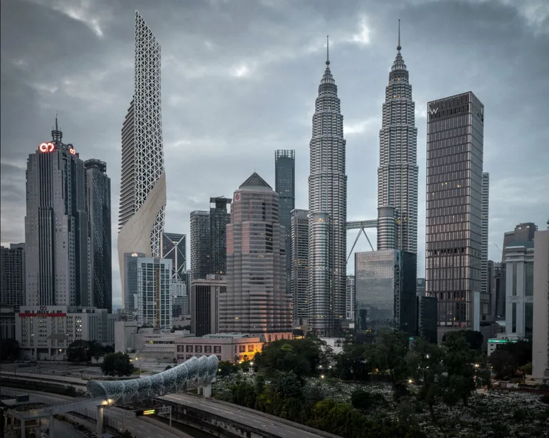 Cityscape view of the perforated tower facade among surrounding high-rises under stormy evening skies
