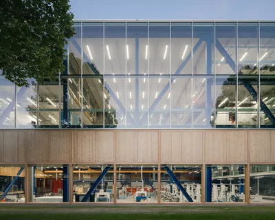 The image showcases a modern industrial building with a striking facade. The building features a com